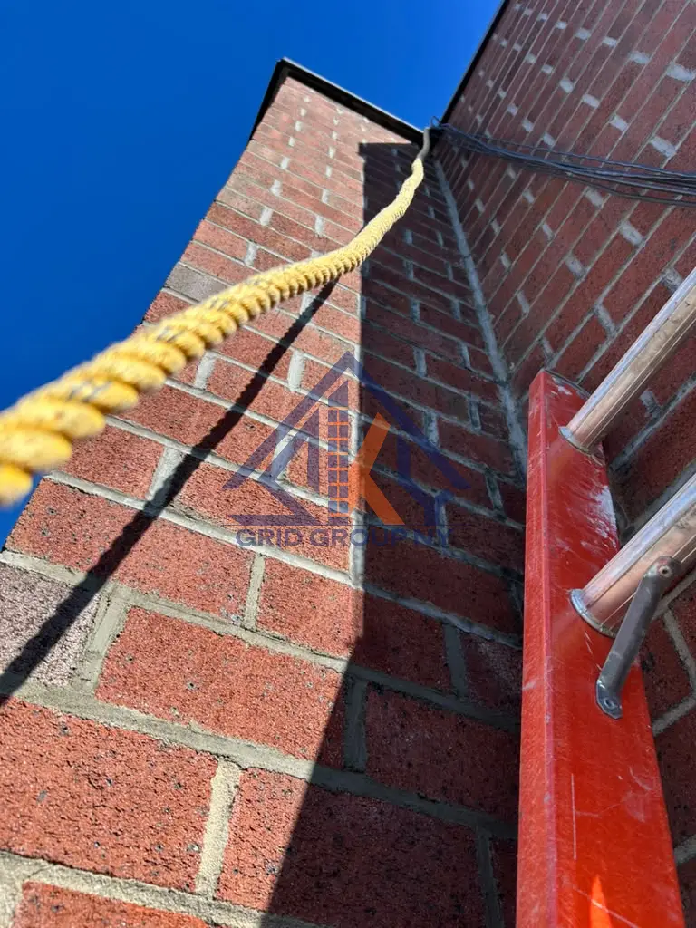 Repointed brick facade at 46-11 88th Street in Elmhurst, Queens, with the crew ladder and safety rope in place