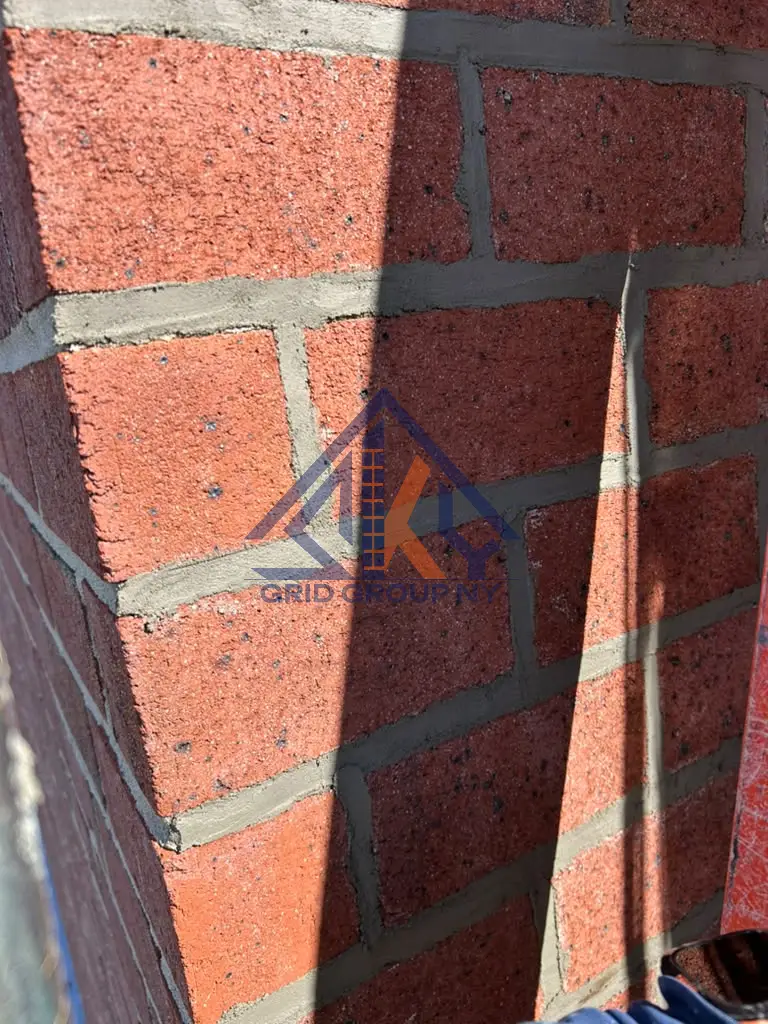 Repointed brick pier beside the crew ladder on the facade at 46-11 88th Street, Elmhurst